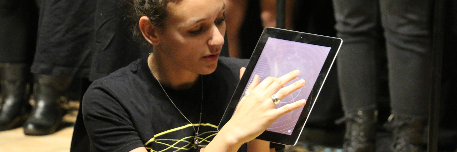 A woman holds an electronic tablet.